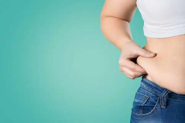 Image of woman pinching her love handles to show weight gain Hounslow